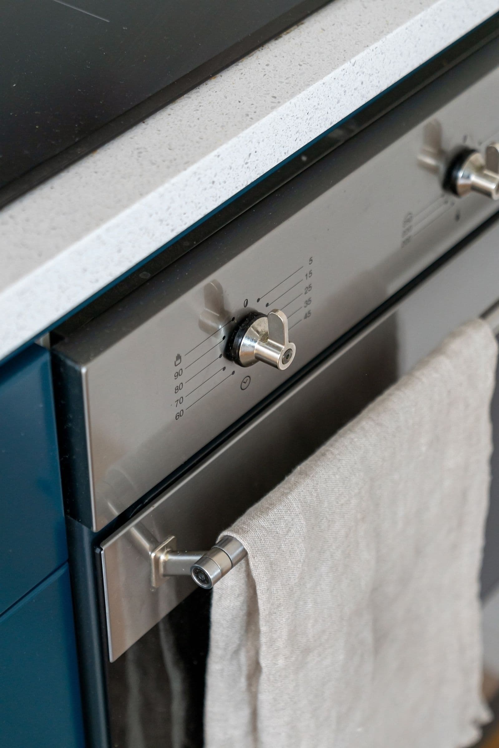 Close-up of a stainless steel kitchen oven with control knobs